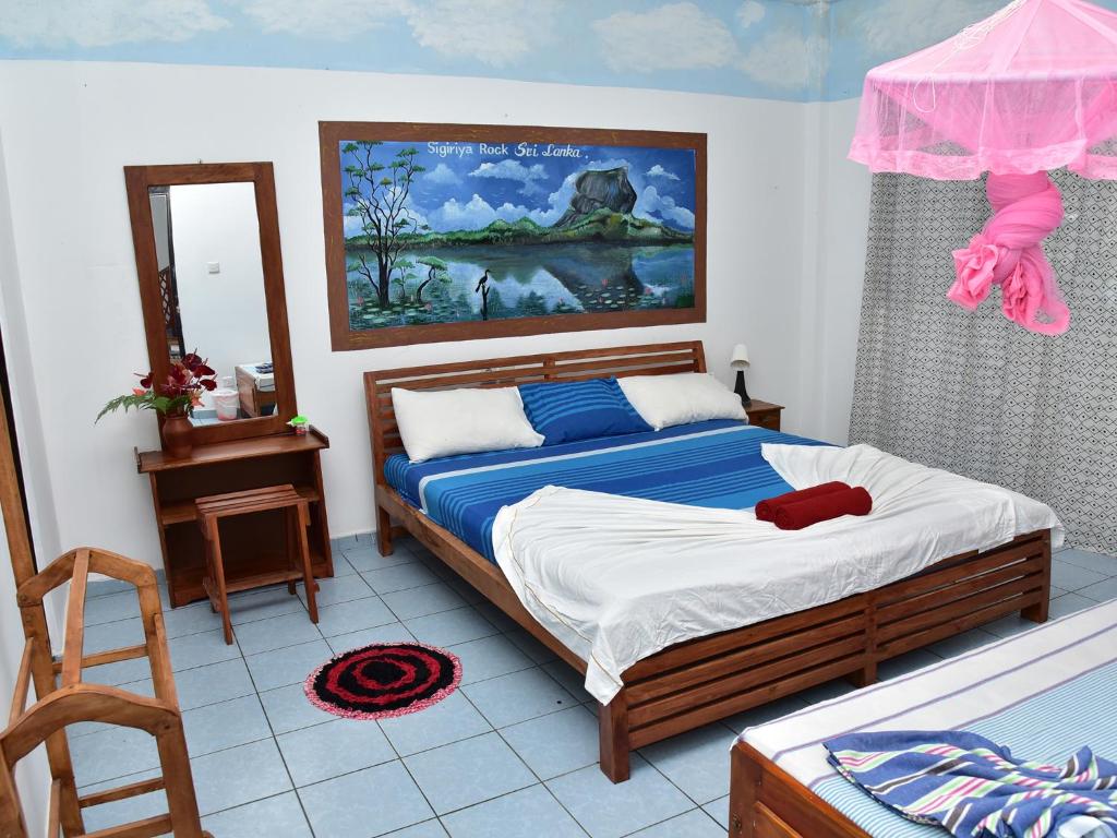 a bedroom with a bed and a mirror at Hotel Happy Tuna in Hikkaduwa