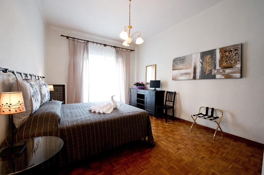 Schlafzimmer mit einem Bett, einem Tisch und einem Fenster in der Unterkunft A Casa Di Enza in Rom