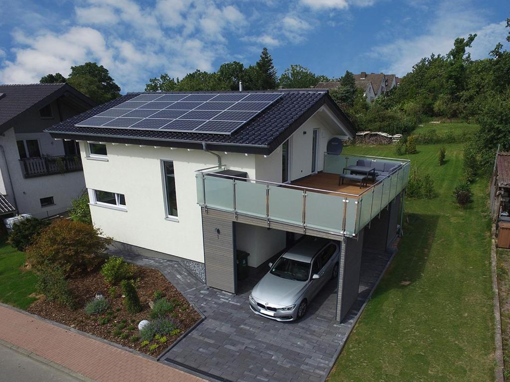 un coche aparcado frente a una casa con paneles solares en Ferienhaus Hofmeyer en Hofgeismar