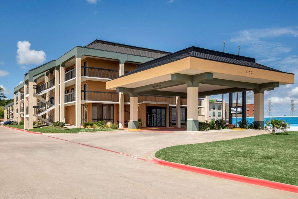 a large apartment building with a parking lot at Quality Inn West Fort Worth in Fort Worth
