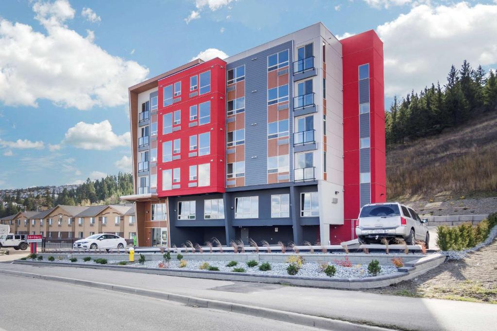 czerwono-niebieski budynek z samochodami zaparkowanymi przed nim w obiekcie The Hue Hotel, Ascend Hotel Collection w mieście Kamloops