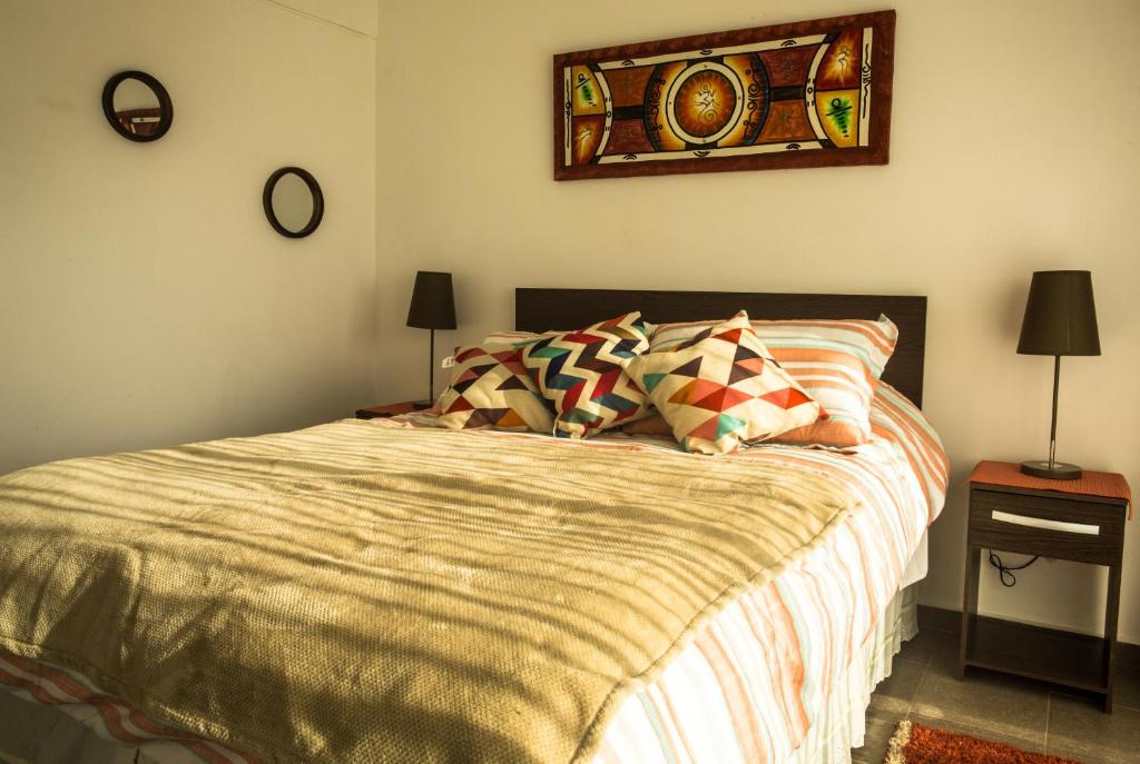 1 dormitorio con 1 cama y una pintura en la pared en Loftbellavistavalparaiso en Valparaíso