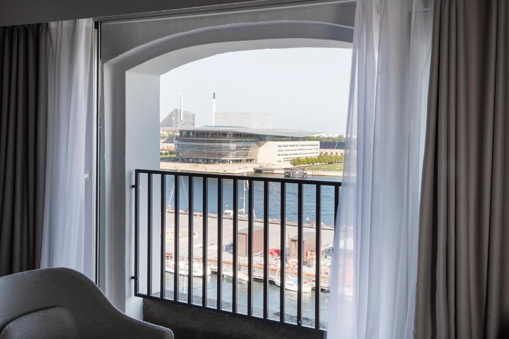 a room with a balcony with a view of a building at Copenhagen Admiral Hotel in Copenhagen