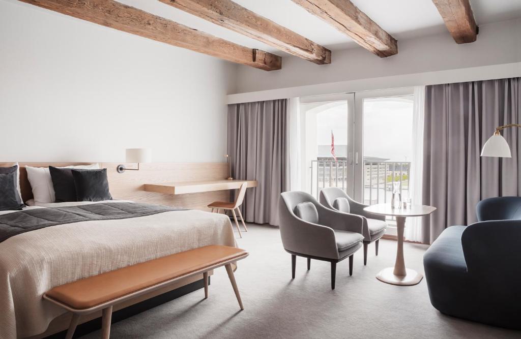 a bedroom with a bed and chairs and a table at Copenhagen Admiral Hotel in Copenhagen