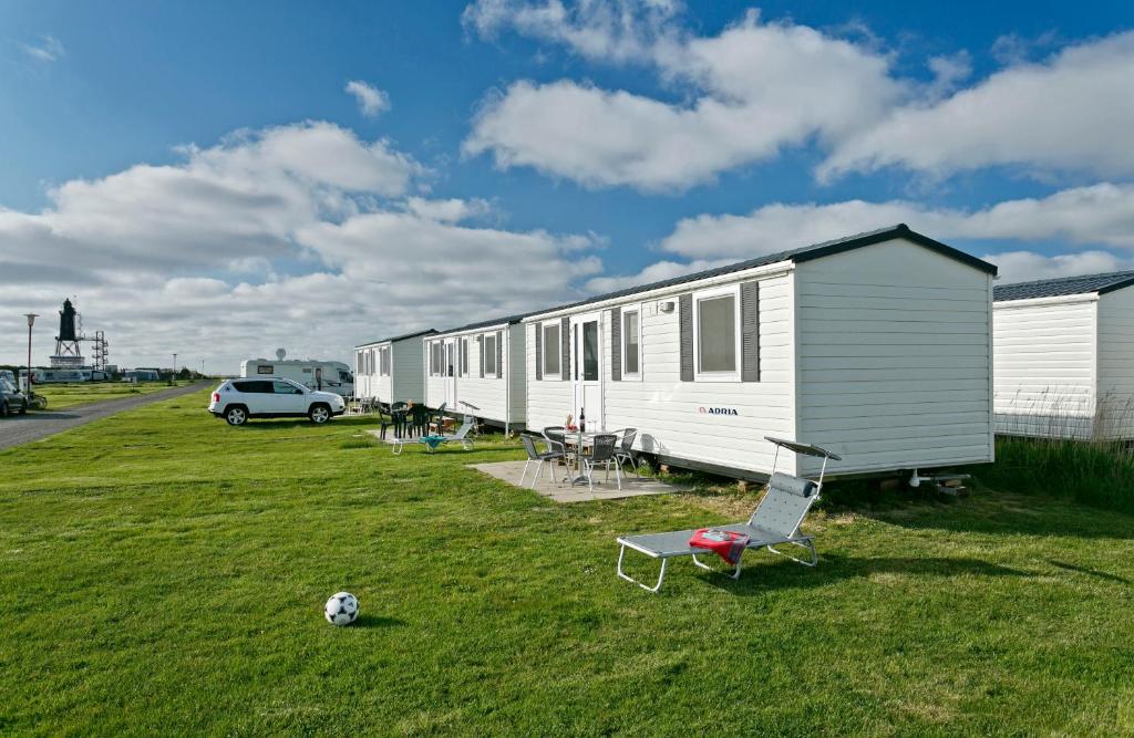 een kleine witte trailer met een voetbal op het gras bij KNAUS Campingpark Dorum in Dorum Neufeld