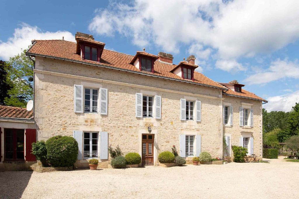 a large stone house with a red roof at Manoir du Moulin in Sainte-Hermine