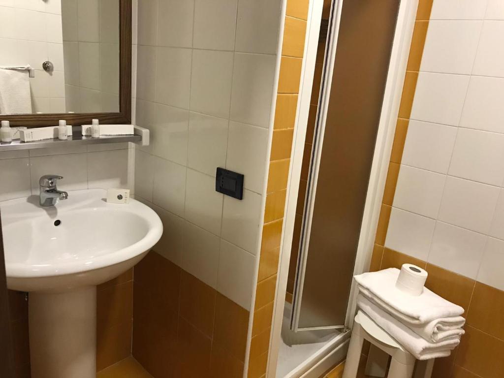 een badkamer met een wastafel en een douche bij Hotel Fly in Casoria