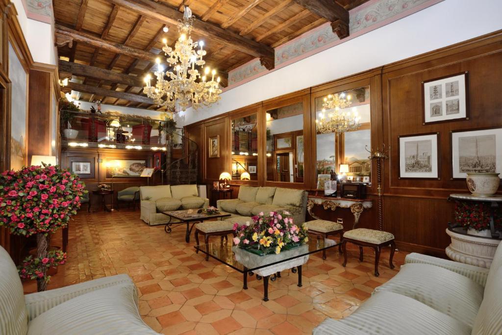 ローマにあるホテル パンテオンのソファとシャンデリア付きの広いリビングルーム