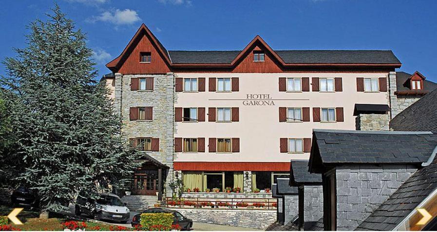 un grande edificio con un albero di fronte di Hotel Garona a Salardú