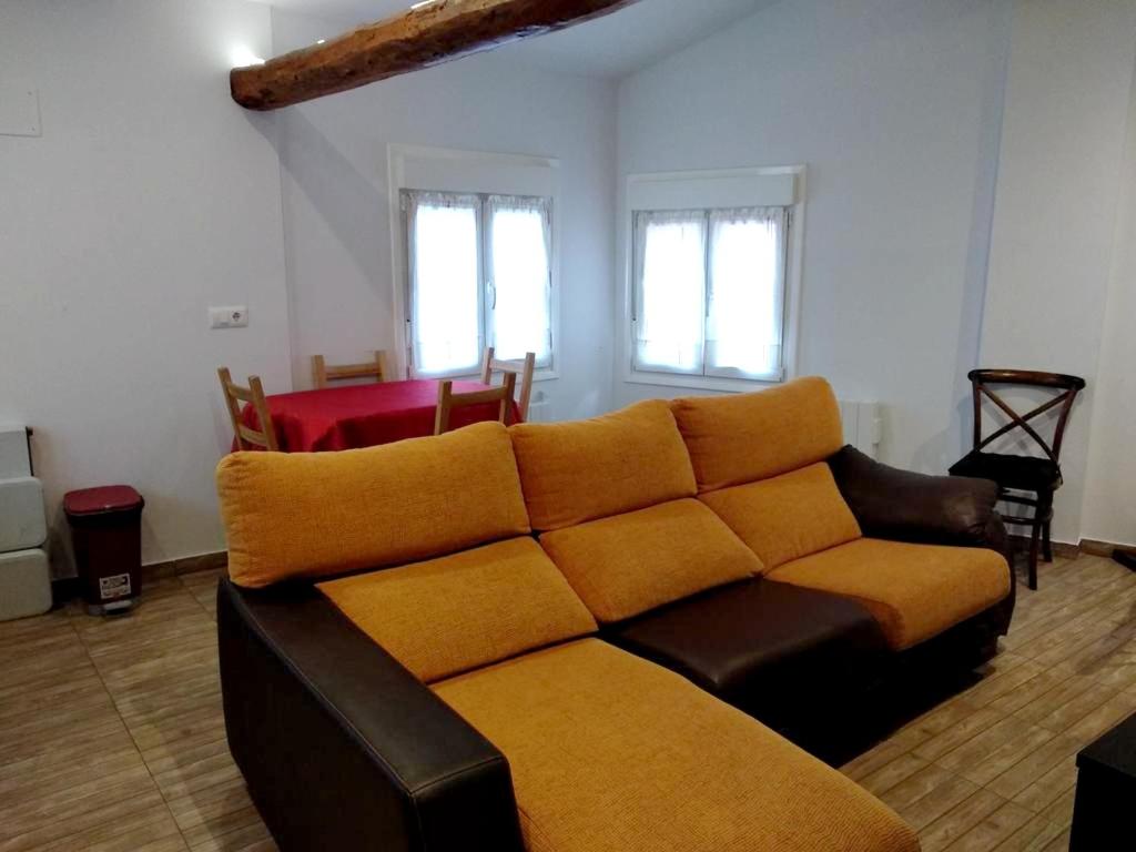 a living room with a brown couch and windows at 2 bedrooms house with terrace and wifi at Arnedillo in Arnedillo
