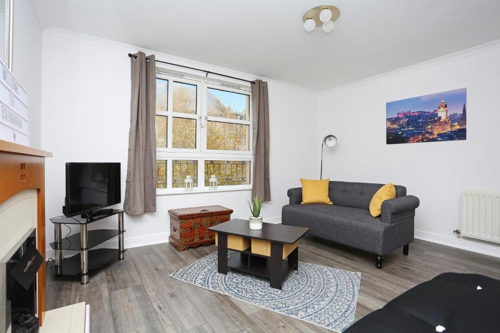 a living room with a couch and a tv at ALTIDO 2BR Apartment with Free Parking, near The Royal Mile in Edinburgh