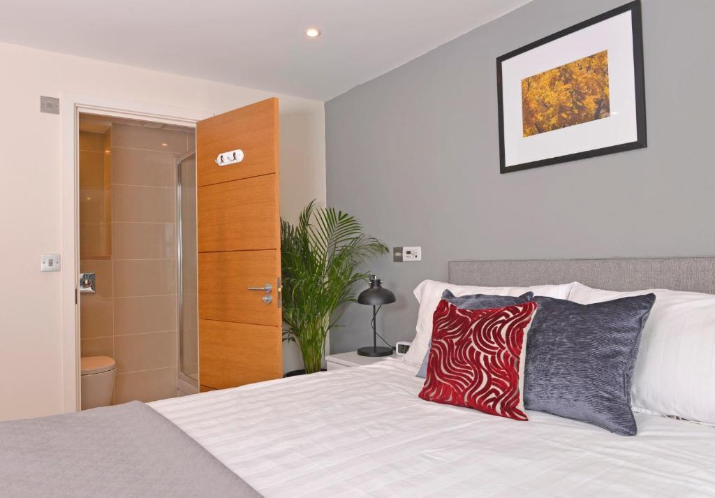 sypialnia z białym łóżkiem i drewnianą szafką w obiekcie The Playwright w mieście Eastbourne