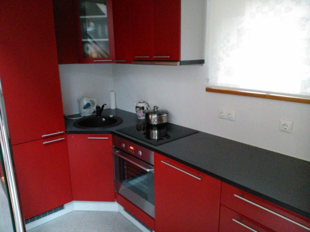 a red kitchen with red cabinets and a sink at Pullijärve Holiday Park in Misso