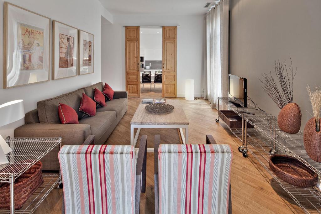 バルセロナにあるHabitat Apartments Rambla Deluxeのリビングルーム(ソファ、テーブル付)