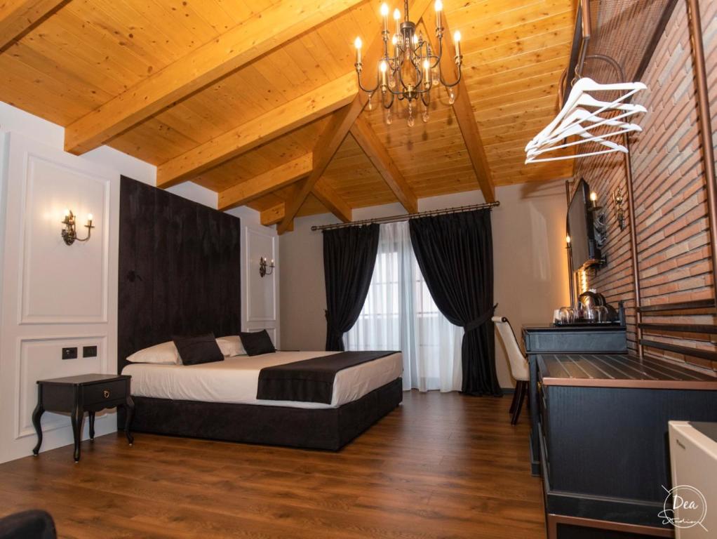 a bedroom with a bed and a wooden ceiling at Hotel Kloest in Durrës