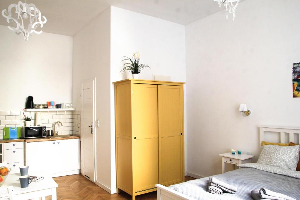 een slaapkamer met een gele kast en een keuken bij Corner 3 I Old Town I Studio in Krakau