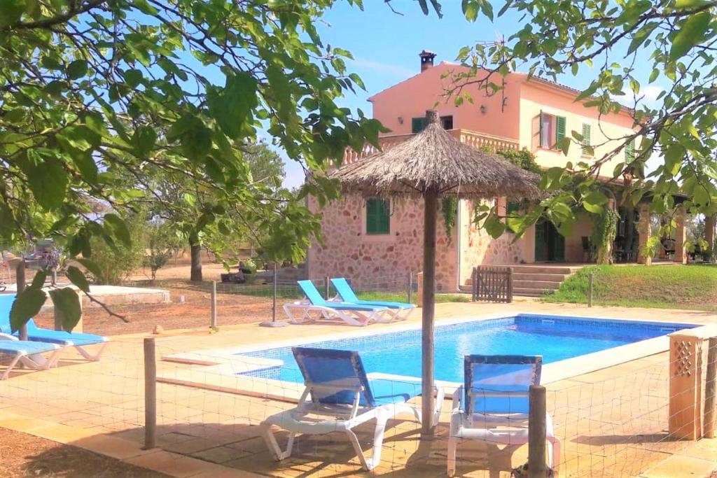 een huis met een zwembad met stoelen en een parasol bij Finca Maravillosa Vista in Campos