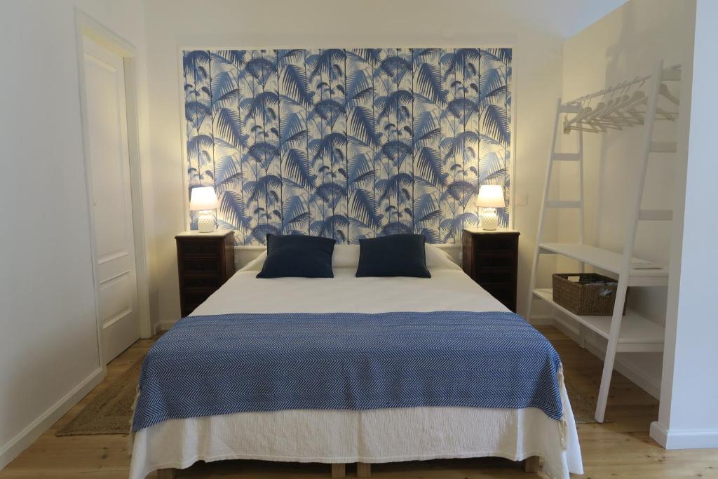 - une chambre dotée d'un lit avec une couverture bleue et blanche dans l'établissement Azul Sul, à Tavira