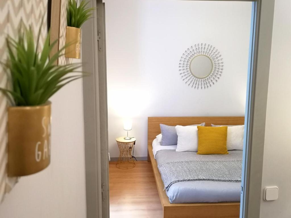 a bedroom with a bed with yellow pillows and a mirror at Apartamentos Fucar in Madrid