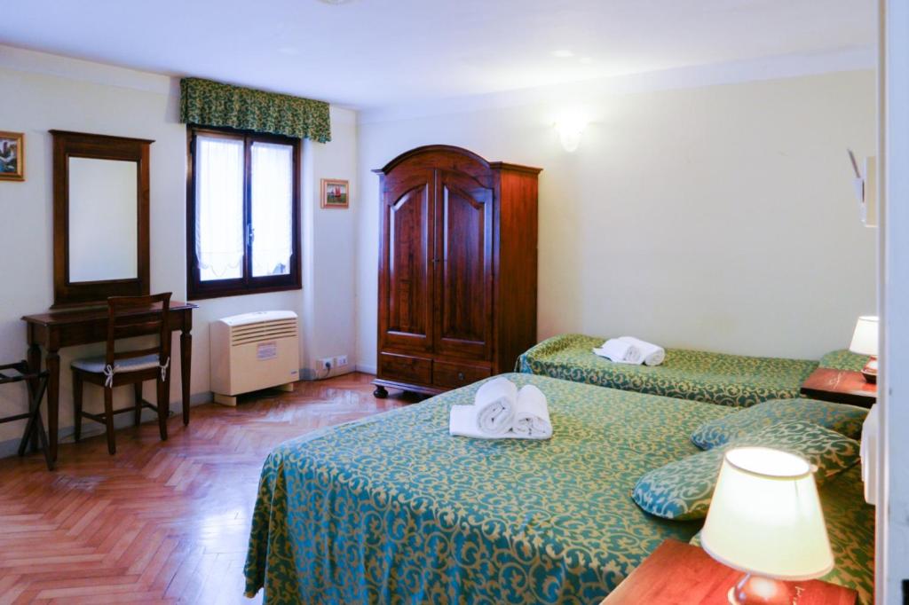 a hotel room with two beds and a piano at Corte Canal Venice in Venice