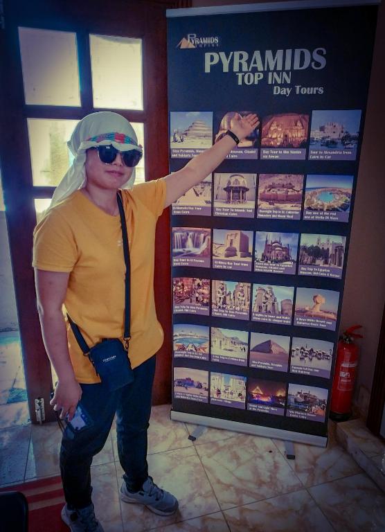 a man is standing in front of a sign at Pyramids Top Inn in Cairo