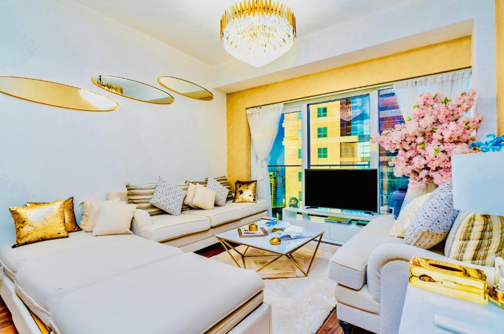 a living room with two couches and a tv at Damac Heights by Fendi casa in Dubai