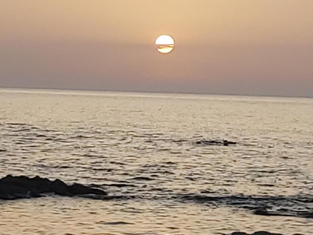einen Sonnenuntergang über dem Meer mit der Sonne am Himmel in der Unterkunft Bilocale in Residenza con Vista Mare - B9 in Aglientu