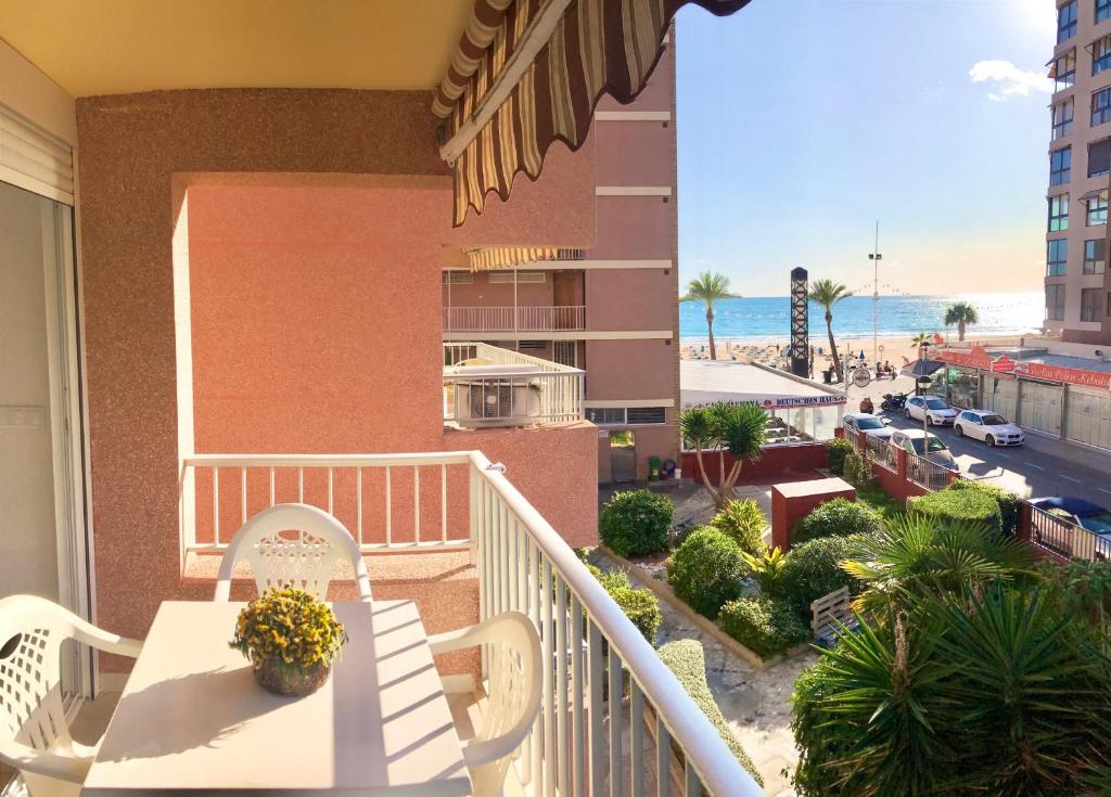 balkon ze stołem i krzesłami oraz widokiem na plażę w obiekcie Los Ranchos Blueline w mieście Benidorm