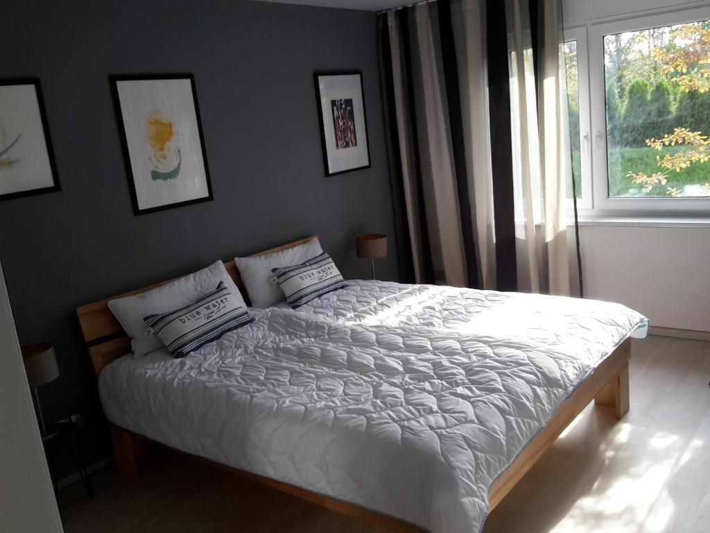 um quarto com uma cama com lençóis brancos e uma janela em Haus Rangau für Ferien-und Messen em Wendelstein