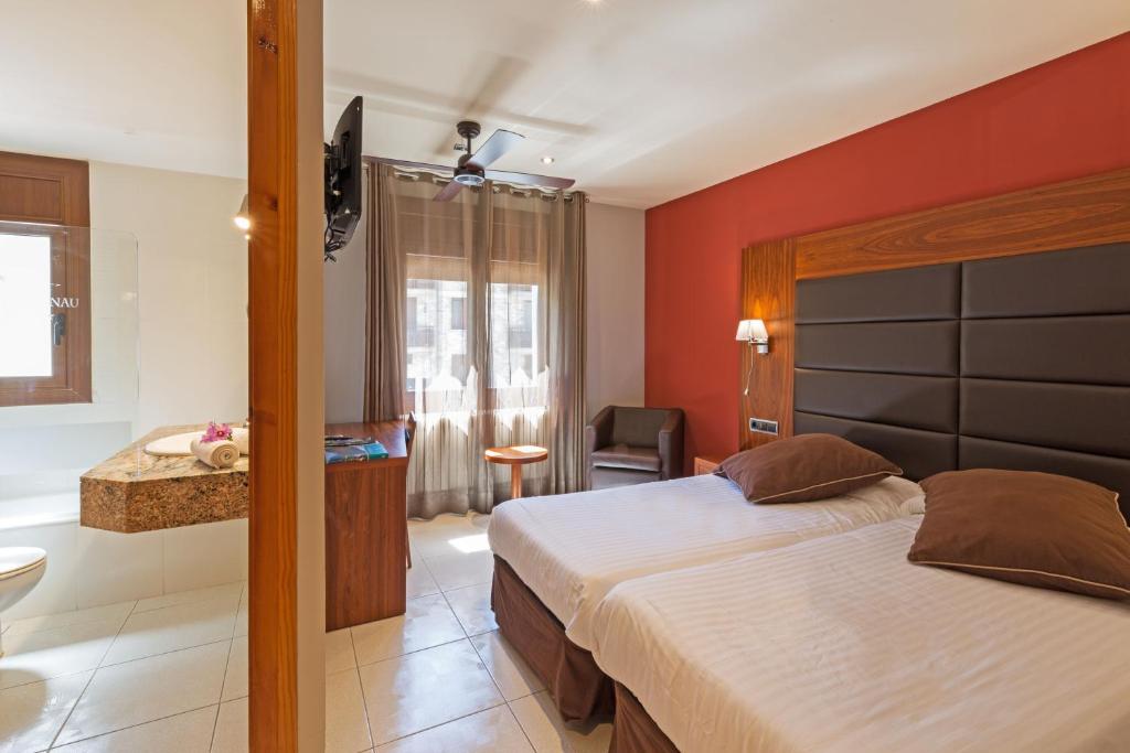 a hotel room with a bed and a bathroom at Hotel Restaurant Castellarnau in Escaló