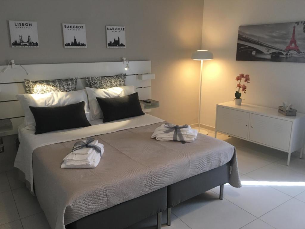una camera da letto con un grande letto con due asciugamani di Il profumo dei Sassi Holiday Home a Matera