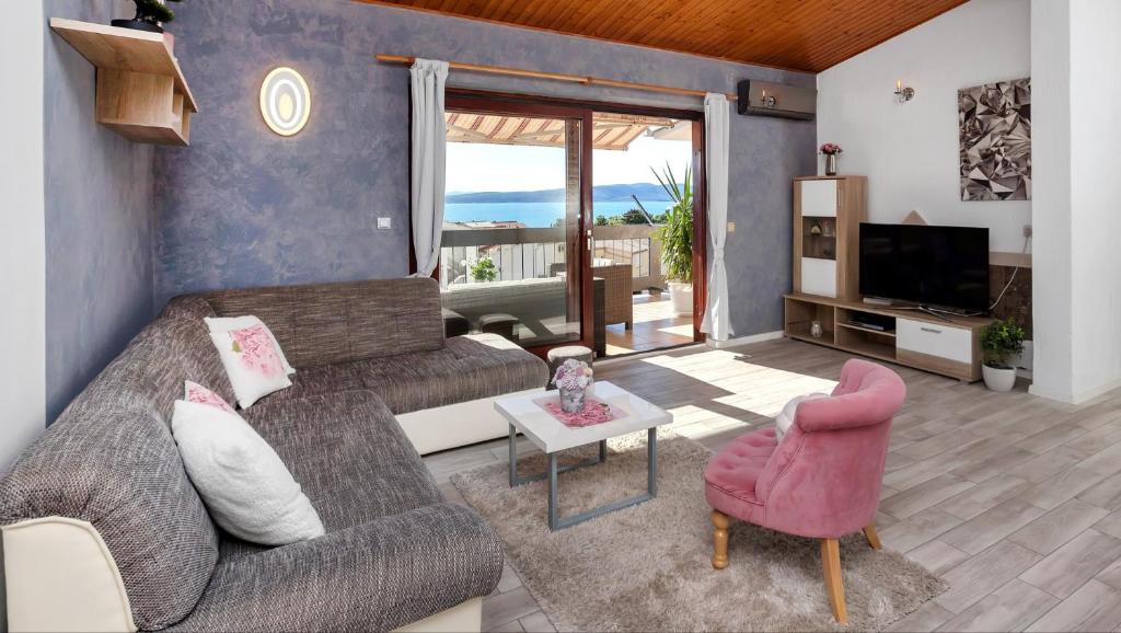 uma sala de estar com um sofá e uma televisão em Apartments Rose em Baska Voda