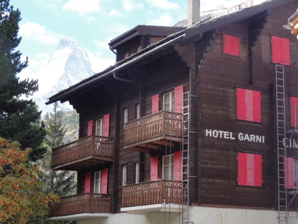 a hotel building with a mountain in the background at Hotel Cima in Zermatt