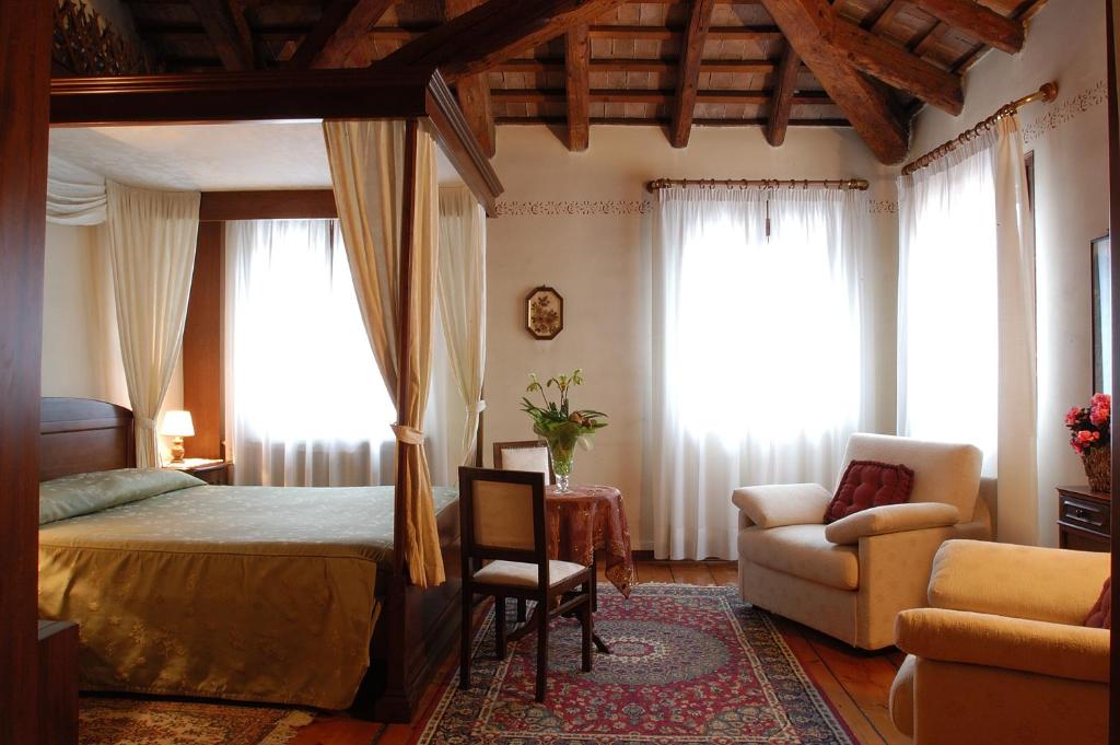 Quinto di TrevisoにあるLocanda Stella D'oroのベッドルーム1室(ベッド1台、ソファ、椅子付)