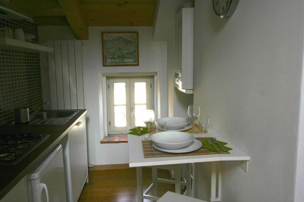 a kitchen with a table with plates and a window at Piazza Grande City Residence in Trieste