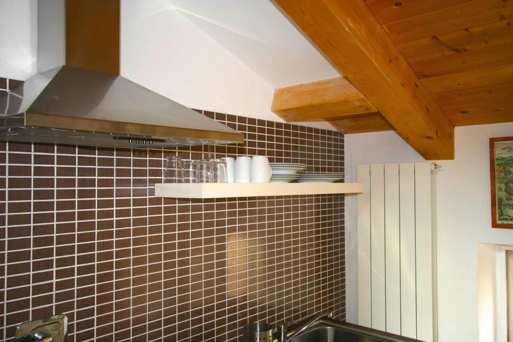 a kitchen with black tiled walls and a stove at Piazza Grande City Residence in Trieste