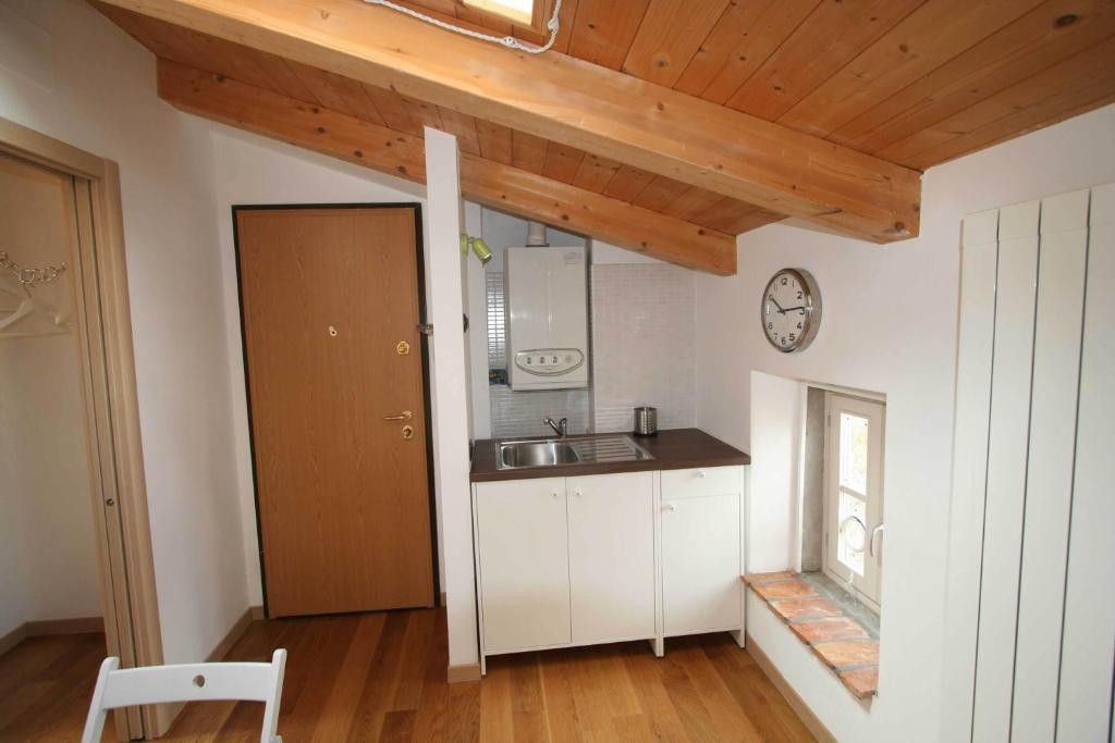 a kitchen with white cabinets and a wooden ceiling at Piazza Grande City Residence in Trieste