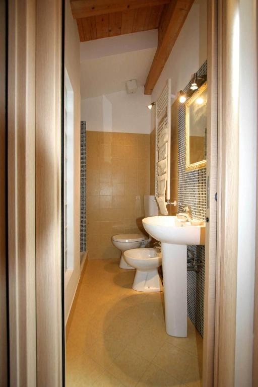 a bathroom with two toilets and a sink at Piazza Grande City Residence in Trieste