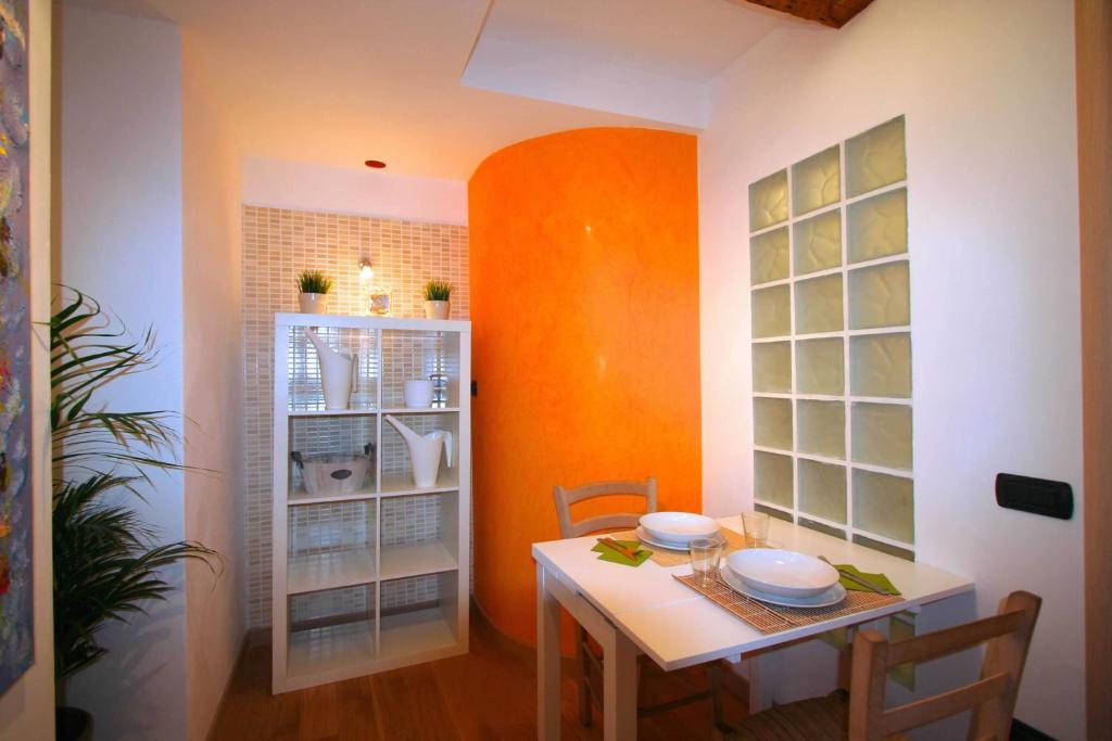 a dining room with an orange wall and a table at Piazza Grande City Residence in Trieste
