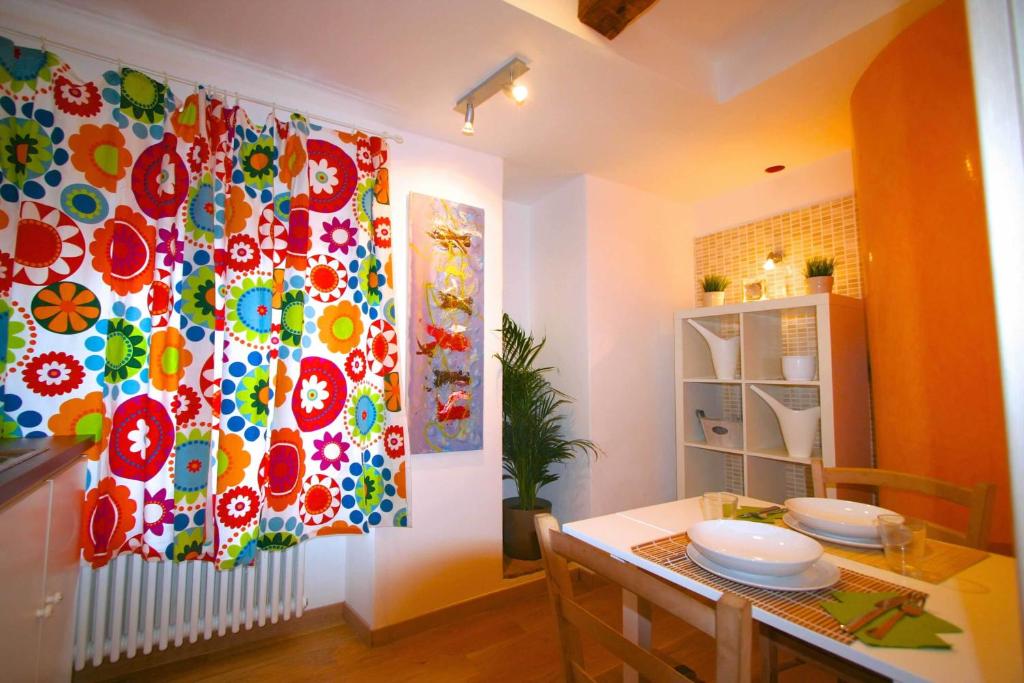 a dining room with a table and a colorful curtain at Piazza Grande City Residence in Trieste