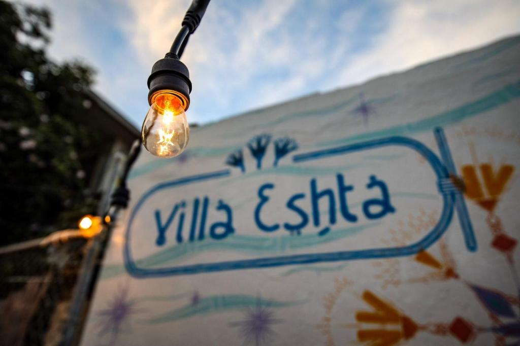 uma luz de rua com um sinal na parede em Villa Eshta em San Juan