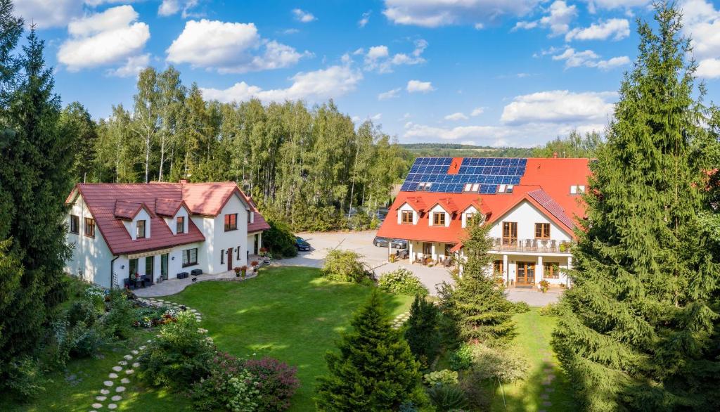 een luchtzicht op een huis met zonnepanelen op het dak bij Pensjonat Leśny Dworek SPA & Garden Uzdrowisko wśród Natury in Cisów