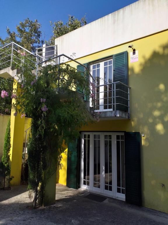 żółty budynek z drzwiami i balkonem w obiekcie Casa Amarante Porto w mieście Amarante