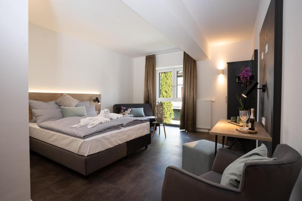 sypialnia z łóżkiem, stołem i krzesłami w obiekcie Drexel`s Parkhotel am Schloss w mieście Krumbach