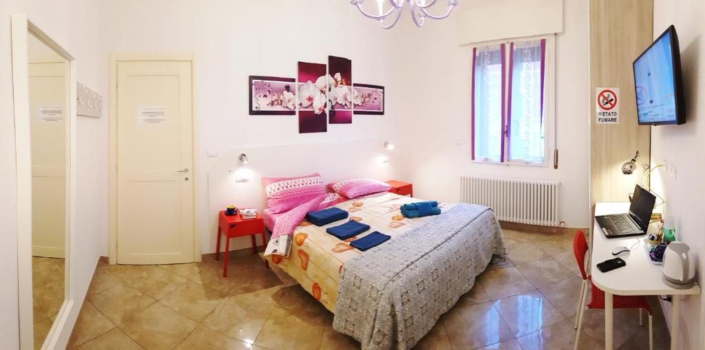 een slaapkamer met een bed, een bureau en een laptop bij Bed And Breakfast Corticella 24 in Bologna