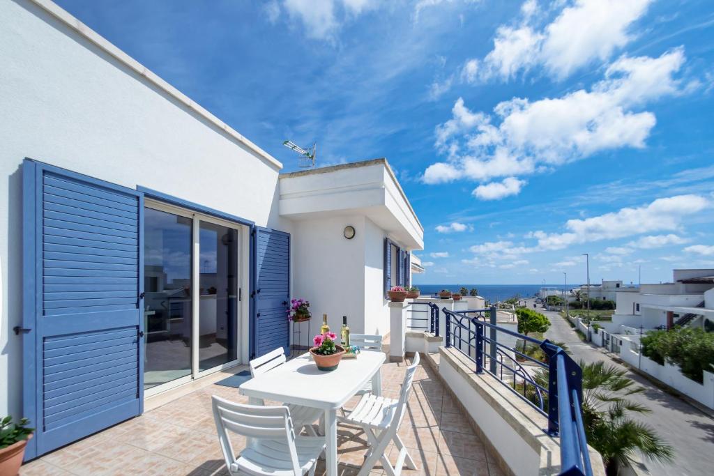 balcone con tavolo, sedie e vista sull'oceano di Deliziosi Appartamenti Sul Mare a Leuca