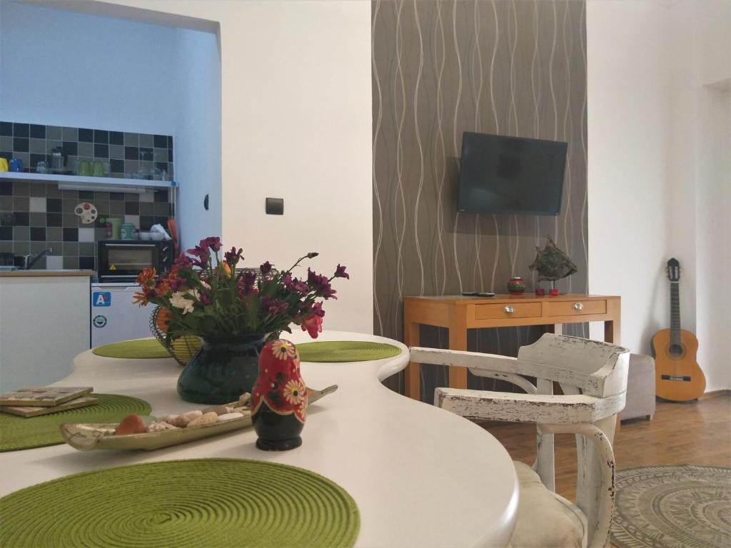 a living room with a white table with flowers on it at City Square Apartment in Chania