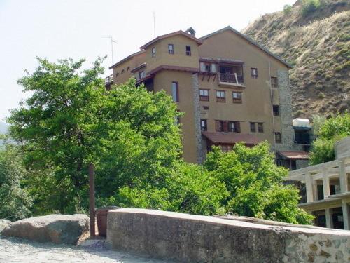 un edificio con árboles frente a un edificio en The Mill Hotel, en Kakopetria