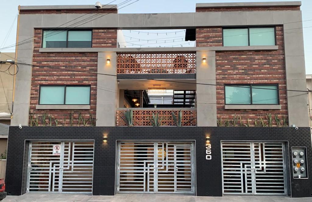 a brick building with two garage doors in front of it at TJ Border Suites by Hosted by Me in Tijuana