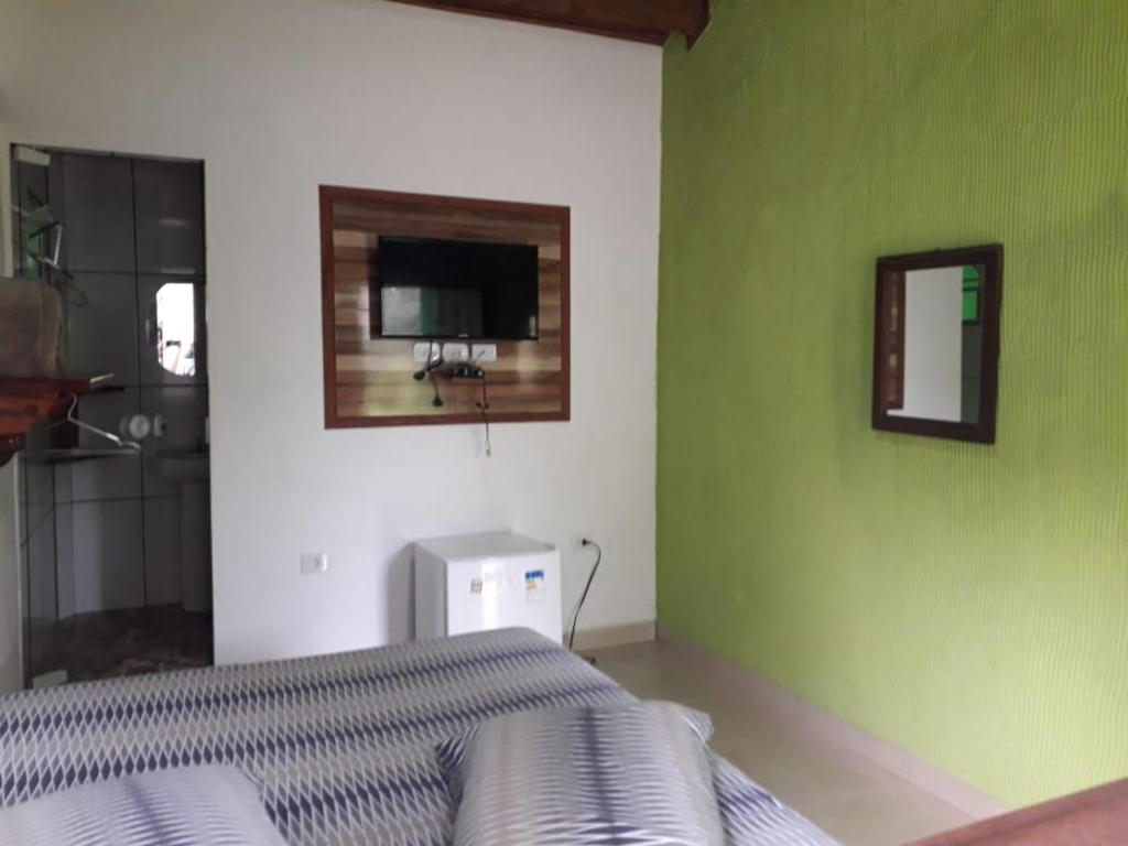 een slaapkamer met een bed en een groene muur bij Siqueira, aluguéis para temporadas in Paraty